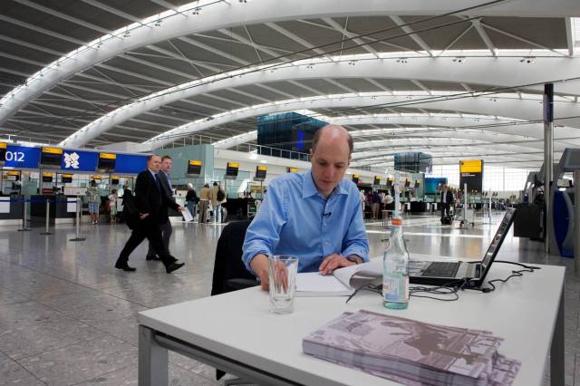 Alain de Botton writing in the new Terminal 5 at Heathrow Airport. Image source: Zocalo Public Square
